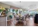 Bright breakfast nook area with hardwood floors, round table, and ample natural light from surrounding windows at 4830 Summerbridge Cir, Leesburg, FL 34748