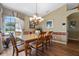 Formal dining room with hardwood floors, a large window, elegant chandelier, and space for a six-person dining set at 4830 Summerbridge Cir, Leesburg, FL 34748