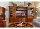 Elegant living room featuring hardwood floors, a large entertainment center, and comfortable seating at 4830 Summerbridge Cir, Leesburg, FL 34748