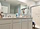Bathroom vanity with double sinks, bright lighting, and a large mirror at 1771 Henin Cir, Tavares, FL 32778