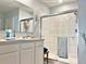 Bright bathroom featuring a glass-enclosed shower, double vanity, and soft blue walls at 1771 Henin Cir, Tavares, FL 32778