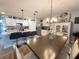 Open concept kitchen with white cabinets, island with seating, and modern lighting fixtures at 1771 Henin Cir, Tavares, FL 32778