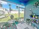 Bright screened-in lanai showcases a peaceful backyard view and comfortable seating area at 1771 Henin Cir, Tavares, FL 32778