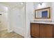 Bright bathroom featuring tile floors, wood cabinets, framed mirror and a shower and tub combo at 26012 Splendid Meadow Ct, Astatula, FL 34705