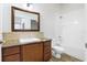 Bathroom featuring a granite countertop, wood cabinets, framed mirror and a shower and tub combo at 26012 Splendid Meadow Ct, Astatula, FL 34705