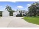 Sprawling white home featuring an attached three-car garage and expansive concrete driveway at 26012 Splendid Meadow Ct, Astatula, FL 34705