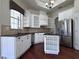 Bright kitchen with stainless steel appliances, stylish white cabinetry and dark countertops and backsplash at 26012 Splendid Meadow Ct, Astatula, FL 34705