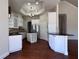 Spacious kitchen featuring stainless appliances, white cabinetry, an island and sleek dark countertops at 26012 Splendid Meadow Ct, Astatula, FL 34705