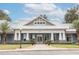 Exterior view of community clubhouse with manicured lawn and palm trees at 10643 Grand Oaks Blvd, Oxford, FL 34484