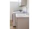 Well-lit laundry room with a washer, dryer, sink, and cabinet at 10643 Grand Oaks Blvd, Oxford, FL 34484