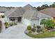 Attractive single-Gathering home with a well-manicured lawn, gray roof, and a spacious driveway leading to a garage at 2968 Wotring Way, The Villages, FL 32163