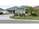 Charming single-story home featuring a beautifully landscaped front yard with lush greenery and a curved driveway at 2968 Wotring Way, The Villages, FL 32163