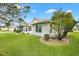 Tan house exterior with a screened porch and landscaped yard at 9400 Se 176Th Saffold St, The Villages, FL 32162