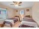Comfortable bedroom featuring two twin beds, ceiling fan, and neutral decor at 1401 W Highway 50 # 12, Clermont, FL 34711