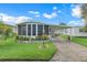 Exterior view of a well-kept mobile home with a manicured lawn and convenient covered parking at 1401 W Highway 50 # 12, Clermont, FL 34711