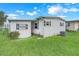 Exterior view of home with light grey siding, dark trim, and green lawn at 1401 W Highway 50 # 12, Clermont, FL 34711