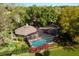 House with pool and screened enclosure; surrounded by lush trees at 1785 Maine Ct, Tavares, FL 32778