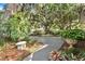 Landscaped front yard with lush greenery, large oak trees, and a concrete path at 1785 Maine Ct, Tavares, FL 32778