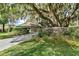 Home with attached garage nestled amongst mature oak trees at 1785 Maine Ct, Tavares, FL 32778