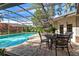 Relaxing pool area with patio furniture under a screened lanai at 1785 Maine Ct, Tavares, FL 32778