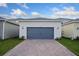 Attached garage with gray doors and a brick paved driveway at 17036 Clear Mind Aly, Winter Garden, FL 34787