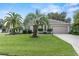 Charming single-story home with lush lawn and tropical landscaping at 1902 Rosario Rd, Lady Lake, FL 32159