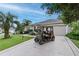 Home exterior with golf cart parked on driveway featuring lush landscaping and gray exterior paint at 1902 Rosario Rd, Lady Lake, FL 32159