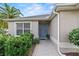 Charming home entrance with a blue front door, complemented by lush green plants and manicured landscaping at 1902 Rosario Rd, Lady Lake, FL 32159