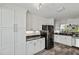 Spacious kitchen featuring ample storage with white cabinets and sleek black appliances at 1902 Rosario Rd, Lady Lake, FL 32159