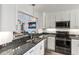 Stylish kitchen featuring granite countertops, stainless steel appliances, and white cabinetry at 1902 Rosario Rd, Lady Lake, FL 32159