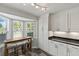 Close-up on a breakfast nook surrounded by white cabinets and a backyard view at 1902 Rosario Rd, Lady Lake, FL 32159