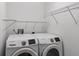 Functional laundry room features washer, dryer, and wire shelving at 1902 Rosario Rd, Lady Lake, FL 32159