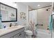 Bathroom with floral shower curtain, gray tile, and a vanity with sink at 6867 Mickylee Run, The Villages, FL 34762