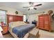 Bedroom with wood headboard, ceiling fan, and a decorative fireplace at 6419 Borg St, Leesburg, FL 34748