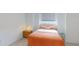 Cozy bedroom featuring an orange comforter, side table and bright light from a window at 115 Lake Emma Cove Dr # 1, Lake Mary, FL 32746