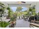 Relaxing screened porch, filled with plants, and outdoor furniture at 38905 Harborwoods Pl, Lady Lake, FL 32159