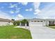 Single-story home with a two-car garage and well-manicured lawn at 1101 Blythe Way, The Villages, FL 32162