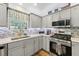 Modern kitchen with stainless steel appliances and gray cabinets at 1101 Blythe Way, The Villages, FL 32162