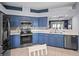 Modern kitchen with blue cabinets and stainless steel appliances at 21835 King Henry Ave, Leesburg, FL 34748