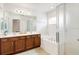 Well-lit bathroom featuring a soaking tub, double vanity, and tiled flooring at 436 Orange Cosmos Blvd, Davenport, FL 33837