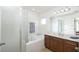 Bright bathroom features a soaking tub with tiled surround and a vanity with a marble countertop at 436 Orange Cosmos Blvd, Davenport, FL 33837