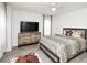 Spacious bedroom with a TV, dresser, and a stylishly decorated bed at 436 Orange Cosmos Blvd, Davenport, FL 33837