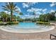 A large community pool surrounded by palm trees and lounge chairs, perfect for relaxation and recreation at 436 Orange Cosmos Blvd, Davenport, FL 33837