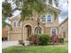 Charming two-story home featuring a clay tile roof, arched entry, and lush landscaping at 436 Orange Cosmos Blvd, Davenport, FL 33837