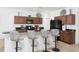 Open kitchen with dark wood cabinets, granite countertops, stainless appliances, and bar stool seating at 436 Orange Cosmos Blvd, Davenport, FL 33837