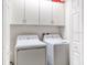 This functional laundry room offers a washer, dryer and plenty of overhead cabinet storage at 436 Orange Cosmos Blvd, Davenport, FL 33837