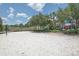 Sandy volleyball court with a net and surrounded by lush landscaping for community enjoyment at 436 Orange Cosmos Blvd, Davenport, FL 33837