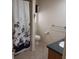 Modest bathroom with a shower and bath curtain, vanity, toilet, and tile floors at 8590 Se 157Th Pl, Summerfield, FL 34491