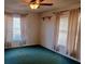 Modest bedroom with two windows, curtains, and green carpet at 8590 Se 157Th Pl, Summerfield, FL 34491