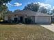 Charming single-story home featuring a well-manicured lawn, attached garage, and inviting front entrance at 8590 Se 157Th Pl, Summerfield, FL 34491